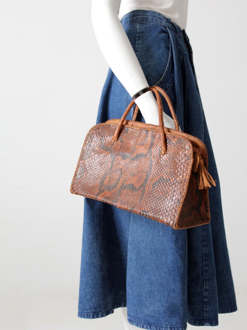 Chic Vintage Snakeskin Satchel Handbag with Leather Accents: Chic Vintage Snakeskin Satchel Handbag with Leather Accents Elevate your accessory collection with this Vintage Snakeskin Satchel. This chic handbag showcases a structured silhouette complemented by t