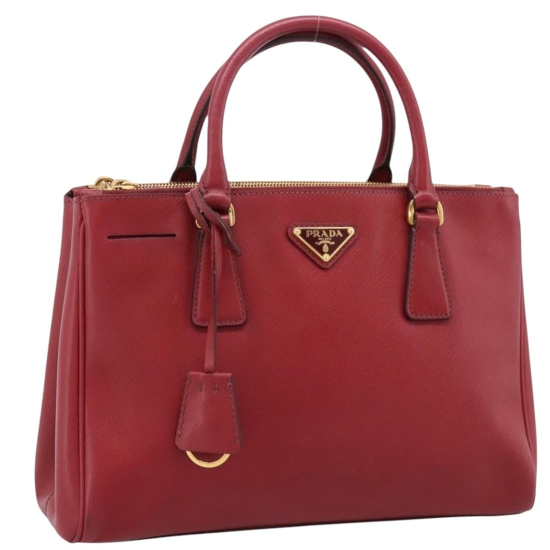 PRADA Saffiano Leather Hand Bag Red with Clochette Italy: PRADA Saffiano Leather Hand Bag Red with Clochette Italy Prada women's handbag in red Saffiano leather with gold-tone accents, made in Italy. Includes a clochette. Condition is heavily used, with visi