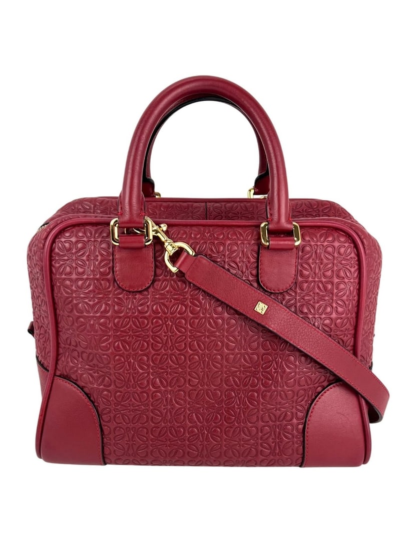 Loewe Amazona Red Leather Shoulder Bag with Gold Hardware: Loewe Amazona Red Leather Shoulder Bag with Gold Hardware Introducing the Loewe Amazona Anagram 2 Way Shoulder Bag, a stylish accessory perfect for casual travel. This medium-sized bag features a slee