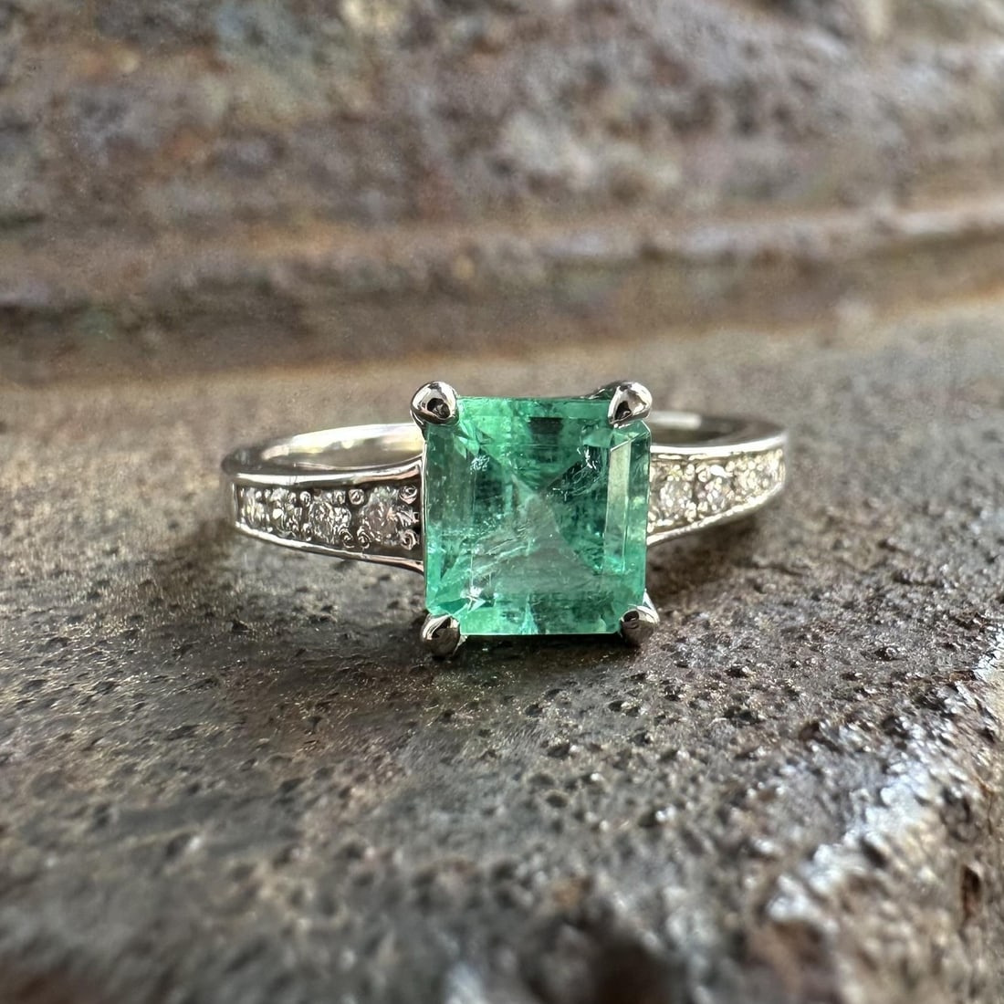 Platinum Emerald Cut Ring with Diamond Shoulders Size 6: Platinum Emerald Cut Ring with Diamond Shoulders Size 6 This vintage platinum ring features a 1.02 carat natural emerald in an emerald cut, prong-set at the center. The emerald displays a lighter gree