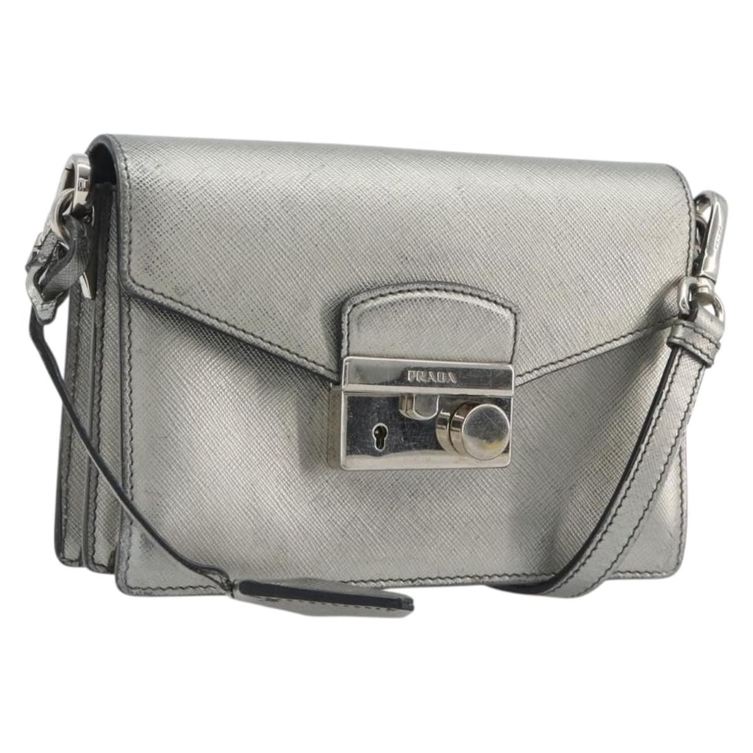 PRADA Saffiano Leather Shoulder Bag in Silver with Clochette: PRADA Saffiano Leather Shoulder Bag in Silver with Clochette Prada shoulder bag in silver Saffiano leather with an adjustable shoulder strap and included key and clochette. Made in Italy, this women's