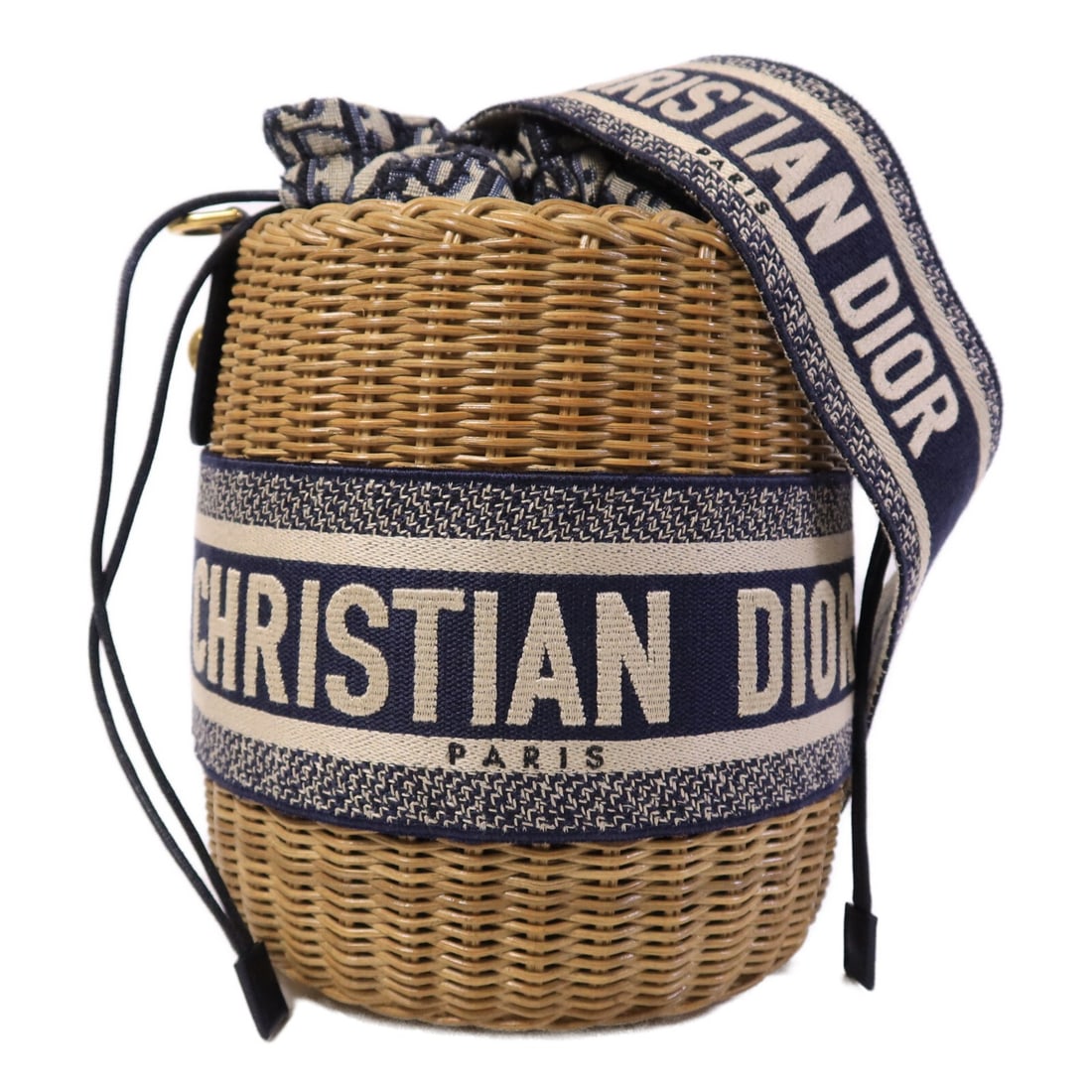 Dior M7600CMROM918 CD Bucket Shoulder Bag Beige Canvas Rattan: Dior M7600CMROM918 CD Bucket Shoulder Bag Beige Canvas Rattan This Christian Dior wicker bucket shoulder bag is crafted from canvas and rattan in a beige and blue color combination. It features an ope