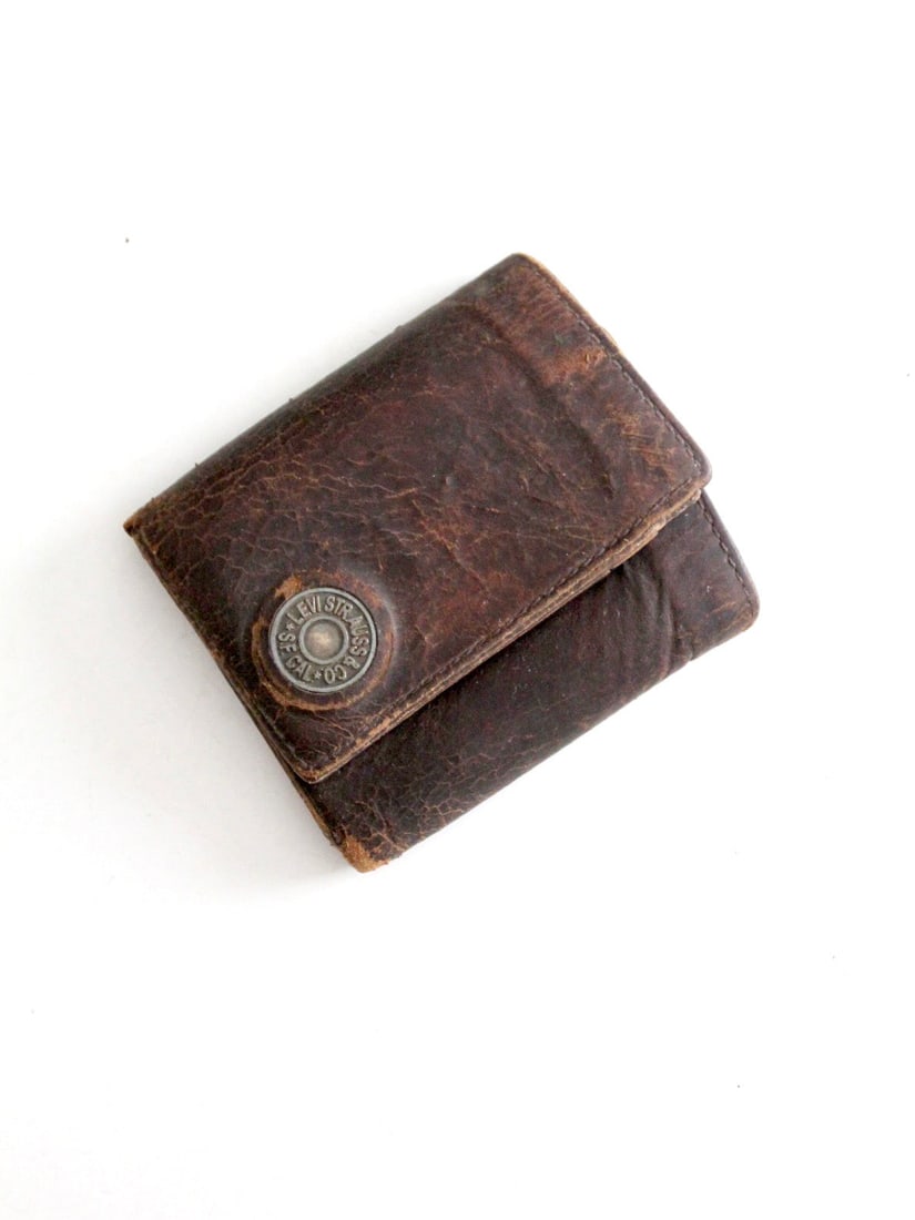 Levi's dark brown leather wallet from the 1970s: Levi's dark brown leather wallet from the 1970s Vintage 1970s Levi's wallet in dark brown leather with a well-worn patina and Levi Strauss & Co. branded metal detail on the front. The interior feature