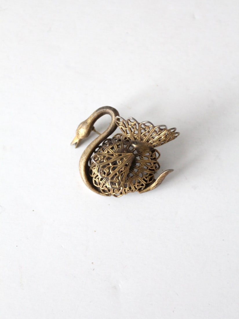 Elegant Vintage Gold Tone Swan Brooch with Filigree Design: Elegant Vintage Gold Tone Swan Brooch with Filigree Design Adorn your outfit with this exquisite vintage swan brooch, crafted in a stunning gold tone. This three-dimensional piece showcases a beautifu