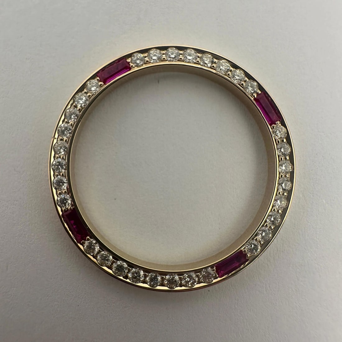 14K Gold Bezel with Diamonds and Rubies for 26mm Datejust: 14K Gold Bezel with Diamonds and Rubies for 26mm Datejust This bezel is designed for Rolex Datejust 26mm models and is crafted from 14k yellow gold. It features approximately 0.64 carats total weight 