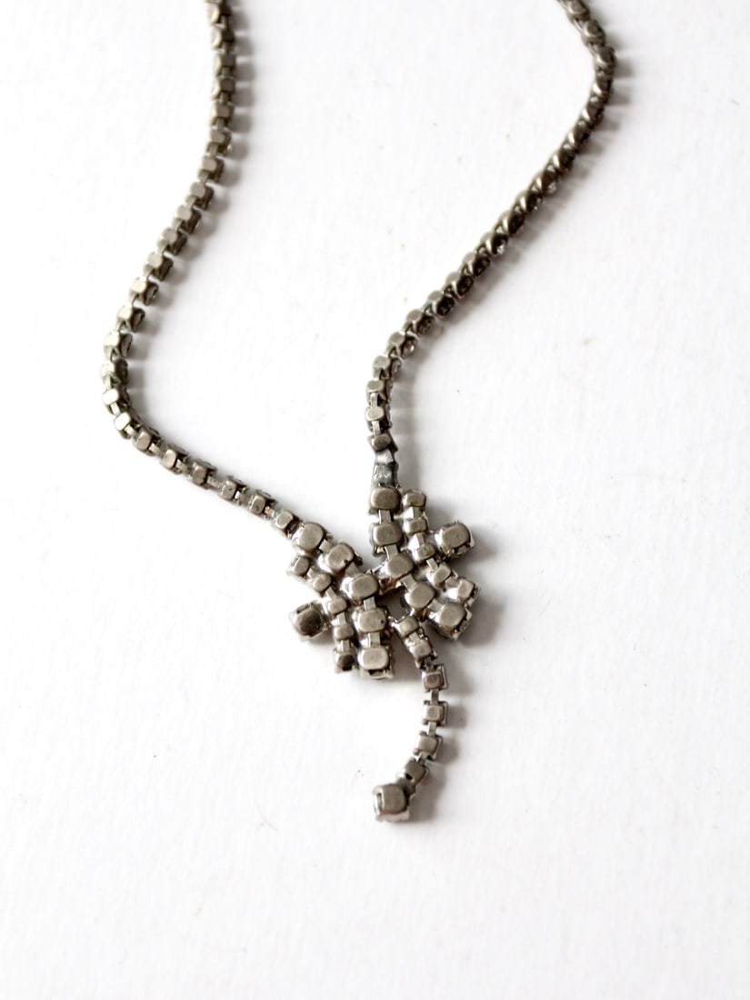 Vintage Rhinestone Drop Necklace with Star Center 15.75 in: Vintage Rhinestone Drop Necklace with Star Center 15.75 in This vintage rhinestone drop necklace showcases a stunning array of prong-set faceted square rhinestones, culminating in a striking star-shap
