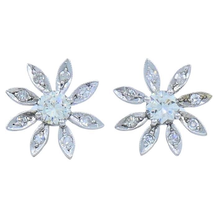Pair of 14k White Gold Diamond Flower Stud Earrings: Pair of 14k White Gold Diamond Flower Stud Earrings Elegant floral stud earrings crafted in 14k white gold with a diamond floral design. Each earring features a central round brilliant cut diamond sur
