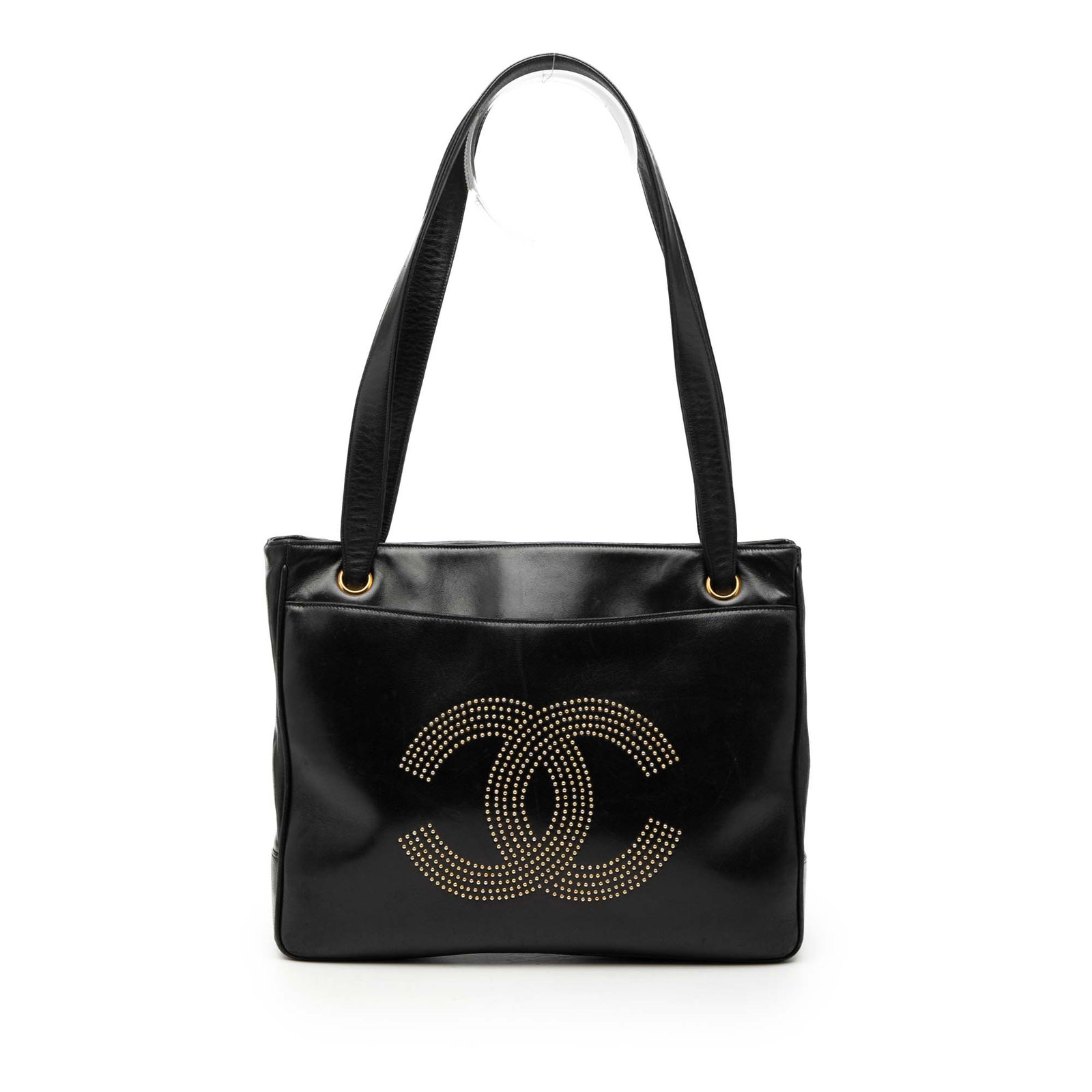 Chanel Black Lambskin Tote with Gold Studded CC Logo: Chanel Black Lambskin Tote with Gold Studded CC Logo This Chanel tote bag is crafted from black lambskin leather and features a front CC logo adorned with gold-tone studs. The bag includes flat leathe