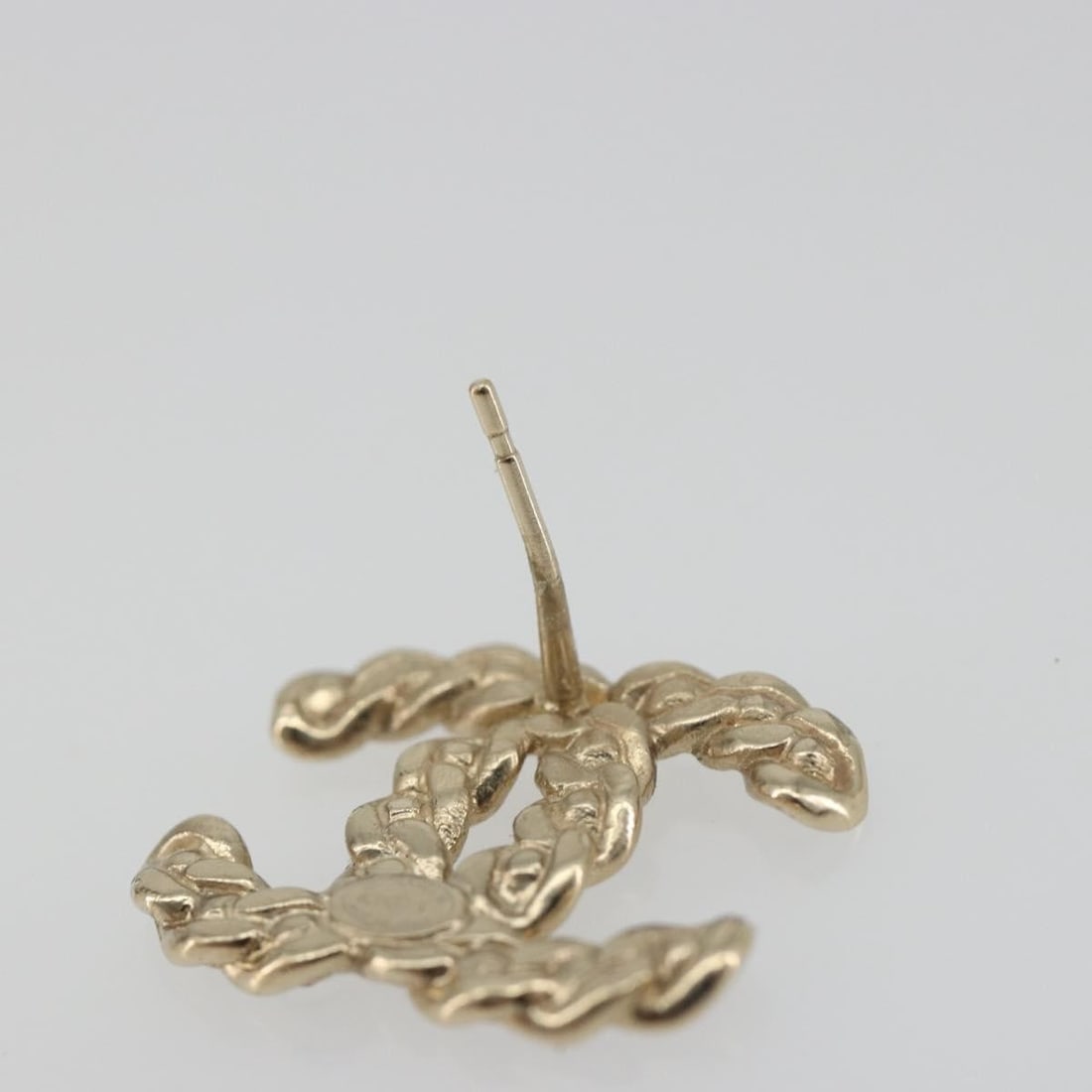 CHANEL CC Gold Tone Metal Earring Made in Italy: CHANEL CC Gold Tone Metal Earring Made in Italy Authentic CHANEL women's earring in gold-tone metal, made in Italy. This piece features the iconic CC motif and is offered without the original box or d