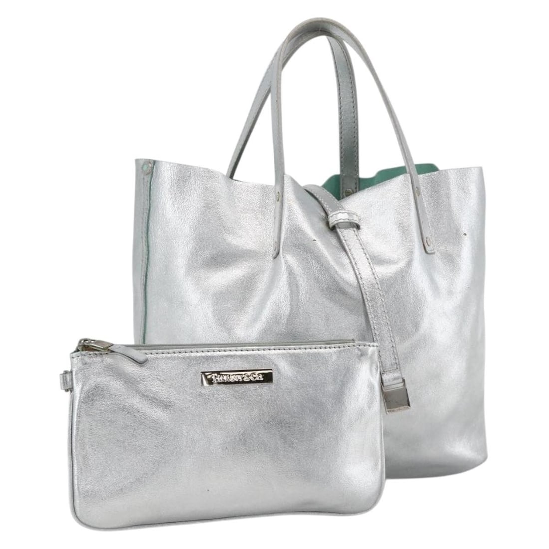 TIFFANY&Co. Silver Leather Reversible Tote Bag with Dust Bag Pouch: TIFFANY&Co. Silver Leather Reversible Tote Bag with Dust Bag Pouch A reversible Tiffany & Co. tote bag crafted in leather with a silver exterior. It is a women's tote made in Italy and comes with a