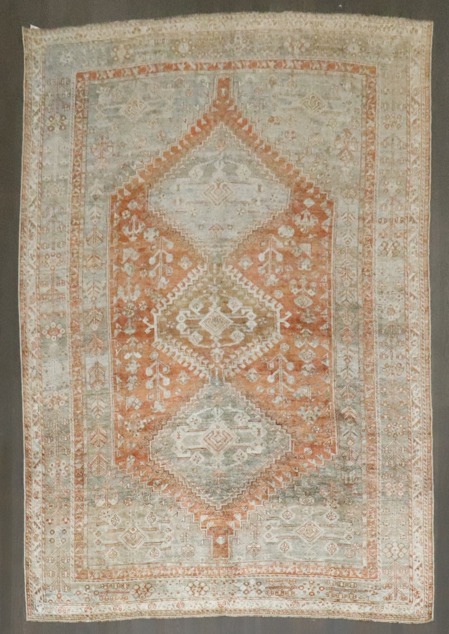 6' 11" x 9' 9" Persian Shiraz Tribal Rug: 6' 11" x 9' 9" Persian Shiraz Tribal Rug Early 20th century Persian Shiraz tribal rug in an apricot colorway. This pre-owned room-size rug is identified as an intermediate-grade Shiraz piece. Specific