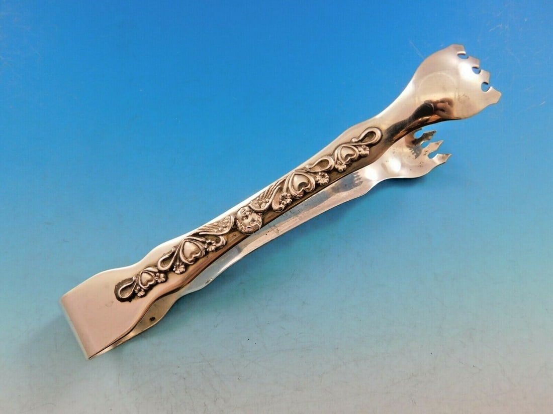 Art Silver 1860-1883 Sterling Silver Ice Tong Angel Cherub Design: Art Silver 1860-1883 Sterling Silver Ice Tong Angel Cherub Design This exquisite sterling silver ice tong, crafted circa 1860-1883, showcases a beautifully detailed applied design on the handle featur