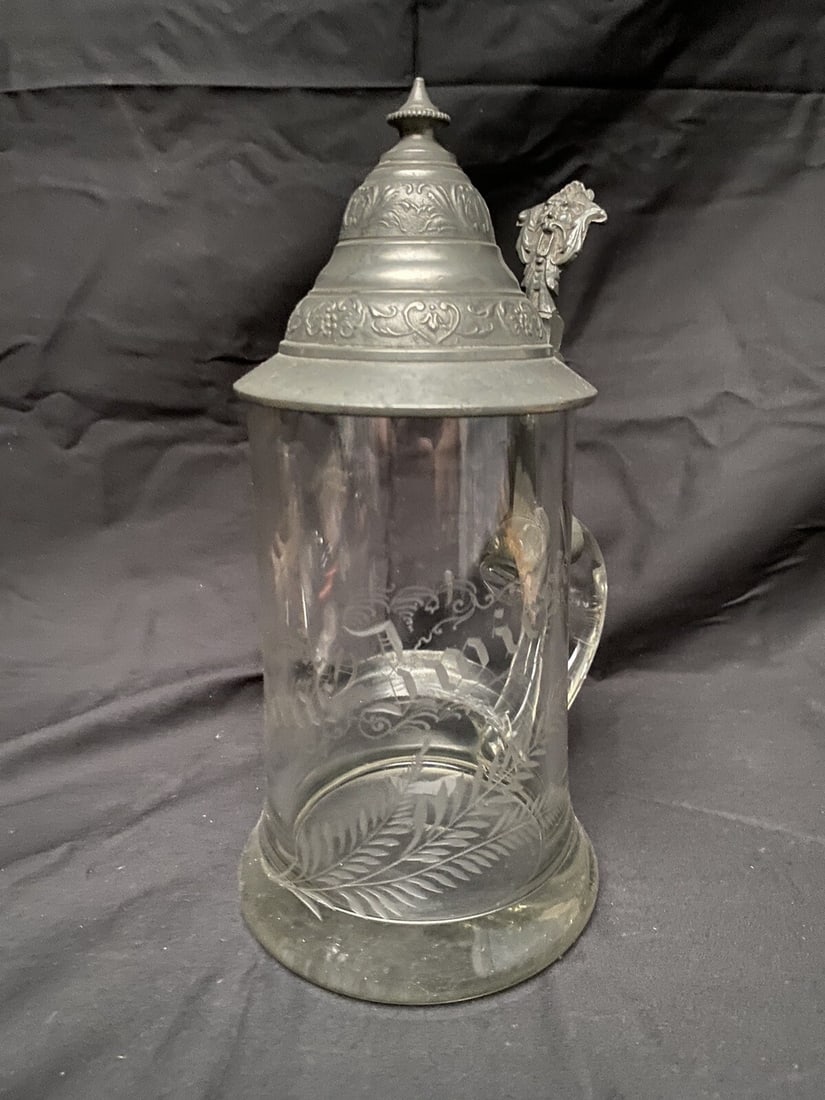 German Brals aus Swiesel Etched Glass Lidded Stein 8.75 in: German Brals aus Swiesel Etched Glass Lidded Stein 8.75 in Antique German lidded stein featuring an etched Brals aus Swiesel advertising design on the front. The decoration includes ornamental element