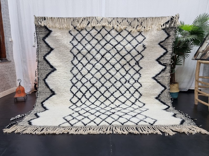 Handmade Moroccan Berber Wool Rug Soft White Geometric Design: Handmade Moroccan Berber Wool Rug Soft White Geometric Design Discover the elegance of this Authentic Soft White Handmade Moroccan Berber Wool Rug, featuring a striking black geometric pattern and an 