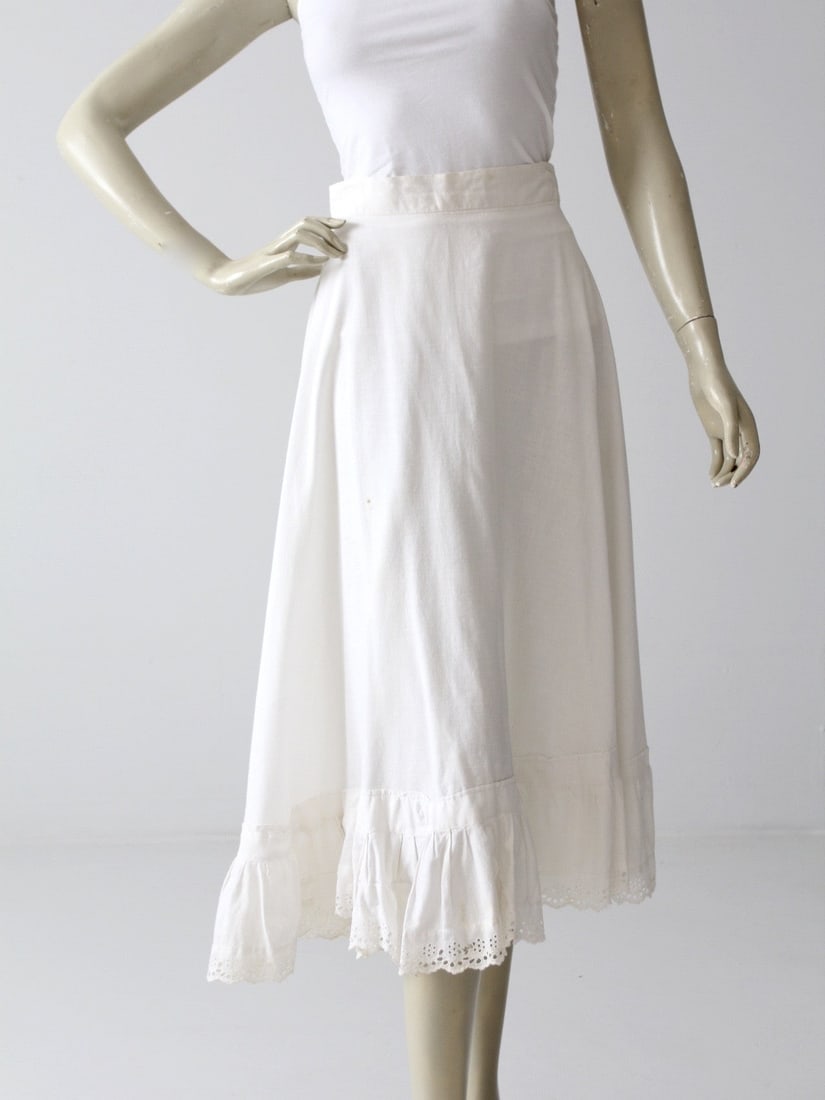 Antique Victorian Cotton Petticoat with Eyelet Lace Trim: Antique Victorian Cotton Petticoat with Eyelet Lace Trim Discover this exquisite antique late Victorian era petticoat. Crafted from crisp white cotton, it features a charming ruffled hem adorned with 