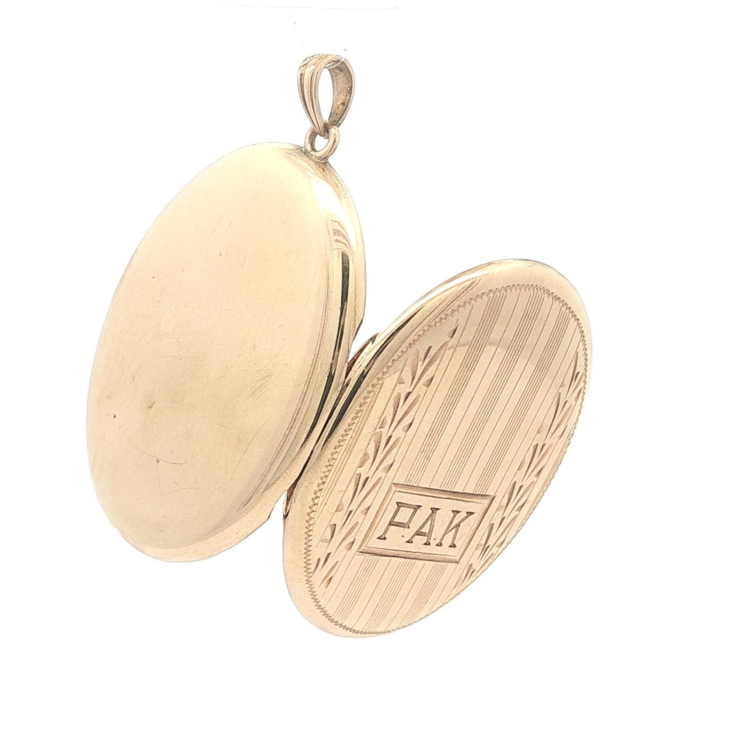 Oval Locket Pendant in 10k Yellow Gold by Esemco with Etched Detailing: Oval Locket Pendant in 10k Yellow Gold by Esemco with Etched Detailing This vintage Esemco locket pendant is crafted from solid 10k yellow gold and features an etched oval design. It includes a clear 