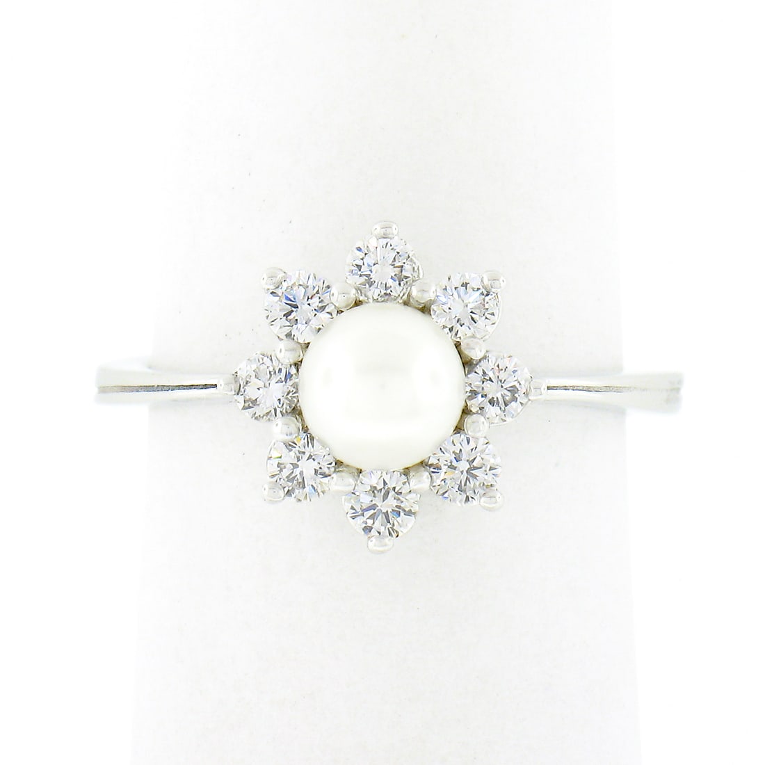 Classic 18k White Gold Pearl and Diamond Flower Cluster Ring: Classic 18k White Gold Pearl and Diamond Flower Cluster Ring This stunning flower cluster ring features a captivating round cultured pearl, measuring 5.25mm, at its center, showcasing a beautiful whit