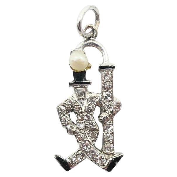 Antique Platinum Figural Gentleman Charm with Pearl Head and Diamonds: Antique Platinum Figural Gentleman Charm with Pearl Head and Diamonds Antique figural charm depicting a walking gentleman with cane, crafted in platinum and set with diamonds. The figure wears a tailo