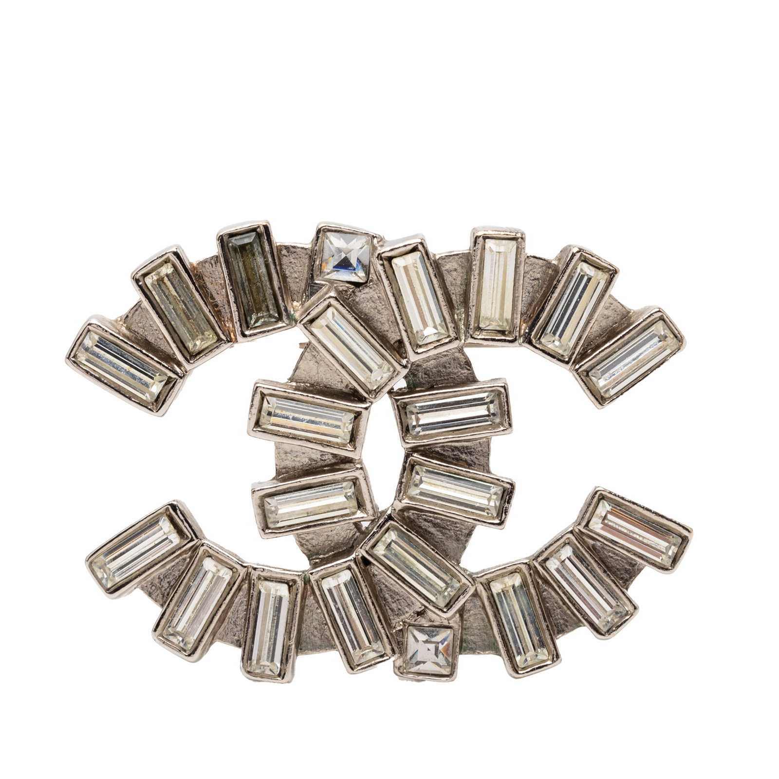 Chanel CC brass strass baguette pin brooch: Chanel CC brass strass baguette pin brooch This Chanel CC Brass Strass Baguette Brooch is crafted from metal with a brass finish and features sparkling strass embellishments. The brooch is designed wi
