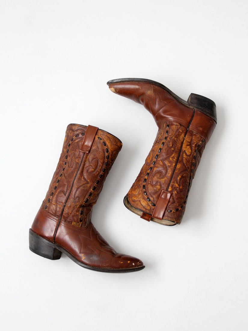1970s Vintage Lariat Cowboy Boots Western Style: 1970s Vintage Lariat Cowboy Boots Western Style Step into the wild west with these vintage 1970s Lariat cowboy boots, showcasing a distinctive lived-in charm. Crafted with brown leather feet and faux 