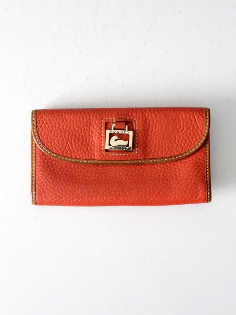 Dooney & Bourke Vintage Pebble Grain Clutch Wallet in Tomato Red: Dooney & Bourke Vintage Pebble Grain Clutch Wallet in Tomato Red Elevate your accessory collection with this vintage Dooney & Bourke Pebble Grain Continental Clutch Wallet. Renowned for its blend of r