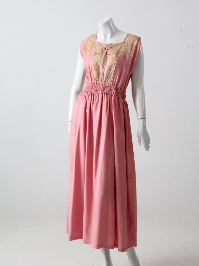 1970s Pink Dress With Lace Front and Smocked Waist Vintage Medium: 1970s Pink Dress With Lace Front and Smocked Waist Vintage Medium This vintage 1970s dress features a soft pink tone with a smocked waist and a relaxed, fluid drape. The bodice is accented by a warm l
