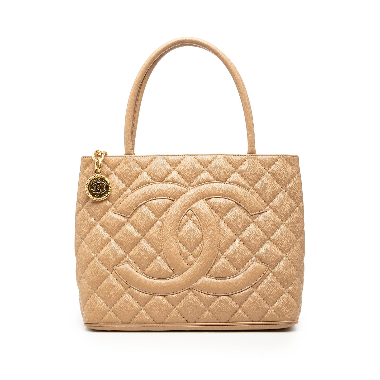 Chanel Medallion Tote in Beige Caviar Leather: Chanel Medallion Tote in Beige Caviar Leather A Chanel Medallion tote bag in beige quilted caviar leather, made in Italy. It features rolled leather handles, a top zip closure, an exterior back slip p