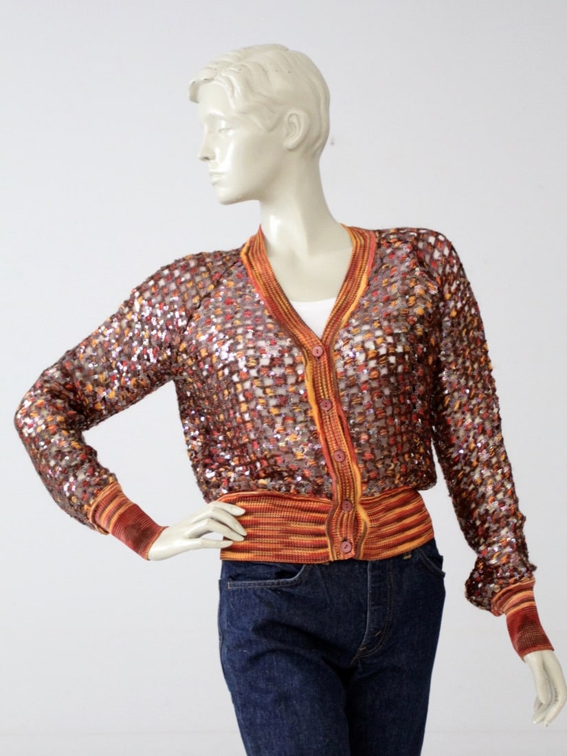 Vintage Missoni Sequin Cardigan in Orange Rust Indigo Tones: Vintage Missoni Sequin Cardigan in Orange Rust Indigo Tones This vintage Missoni cardigan features a vibrant blend of orange, rust, and indigo tones adorned with stunning sequins. The open knit design