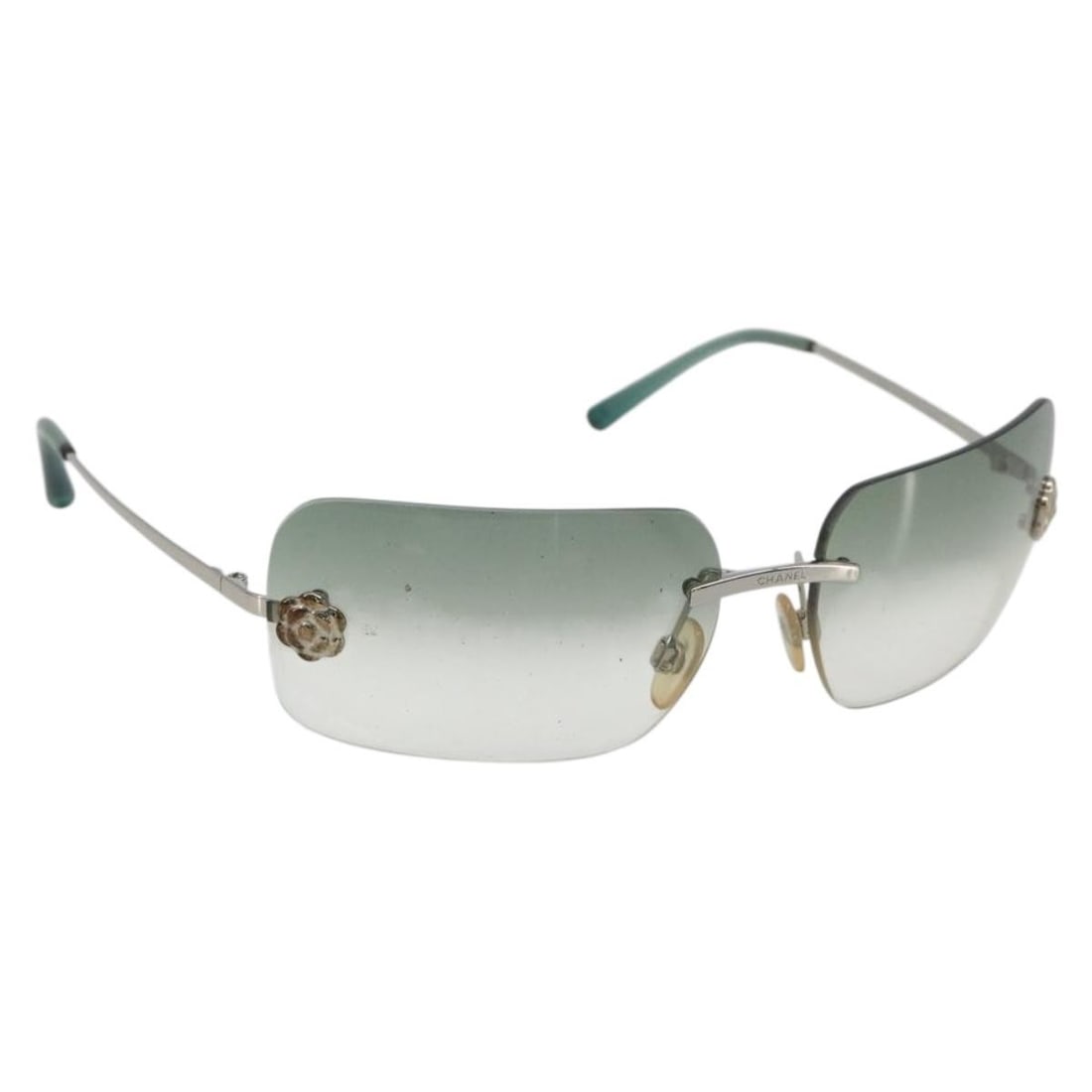 CHANEL Camelia Green Metal Sunglasses with CC Case: CHANEL Camelia Green Metal Sunglasses with CC Case CHANEL Camelia sunglasses in green metal, made in Italy. The item includes a sunglass case and shows reasonable wear and tear, with slight surface sc