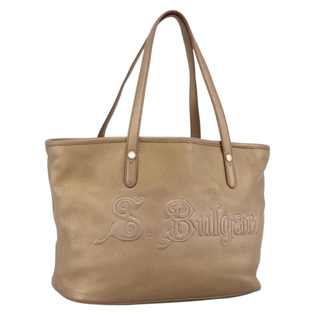 BVLGARI Gold Tone Leather Tote Handbag for Women Italy: BVLGARI Gold Tone Leather Tote Handbag for Women Italy This BVLGARI tote bag for women features a gold tone leather exterior with a structured silhouette. The spacious interior and sturdy handles make