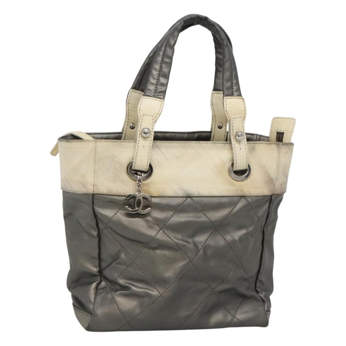 CHANEL Paris Biarritz PM Silver Coated Canvas Tote: CHANEL Paris Biarritz PM Silver Coated Canvas Tote This CHANEL Paris Biarritz PM tote bag is crafted from coated canvas in a silver exterior color. Made in Italy, it features a women's tote bag design