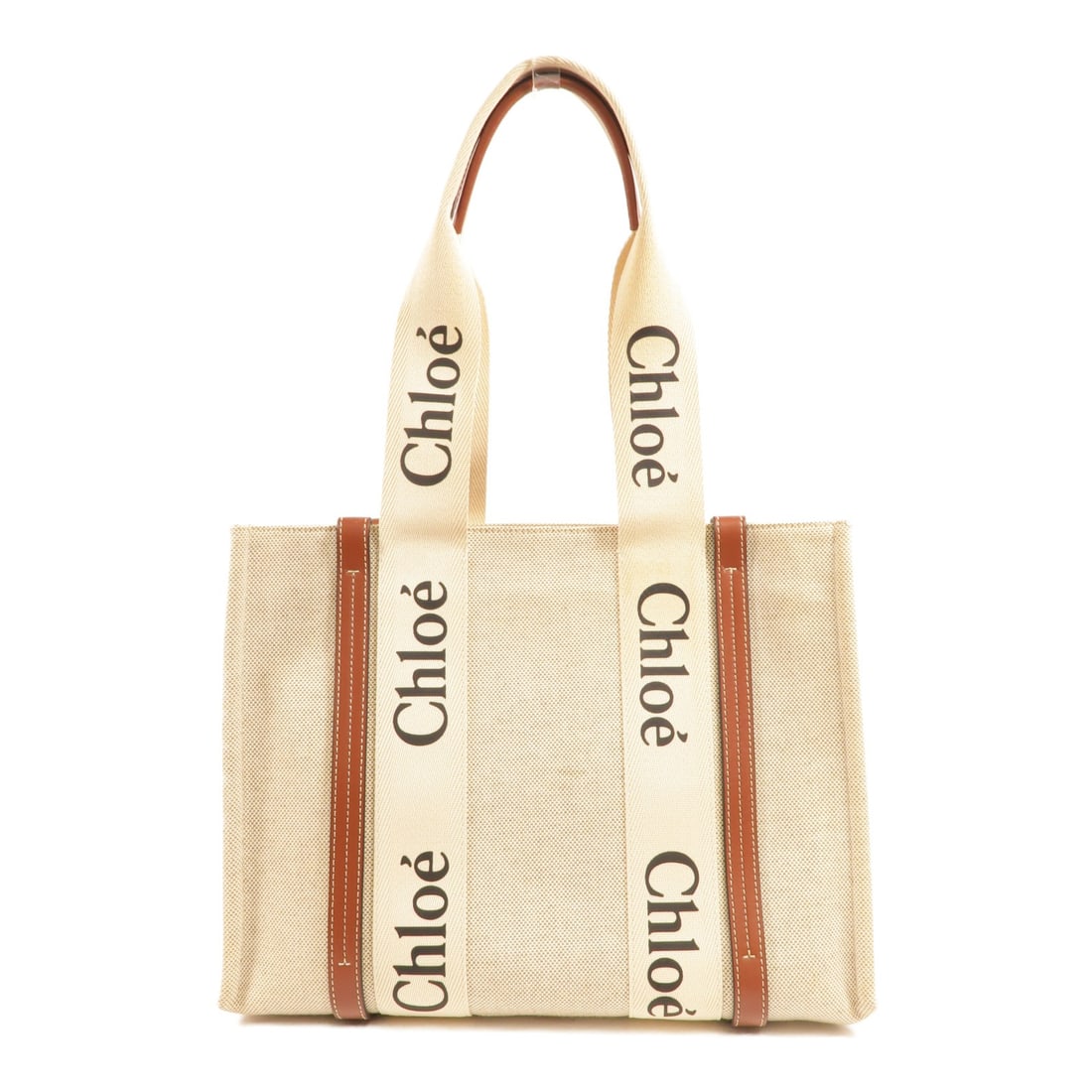 Chloe Woody Canvas Tote Shoulder Bag in Beige: Chloe Woody Canvas Tote Shoulder Bag in Beige Chloe Woody tote bag in beige canvas with brown accents. This women's shoulder tote features an open interior pocket and comes without accessories. Condit
