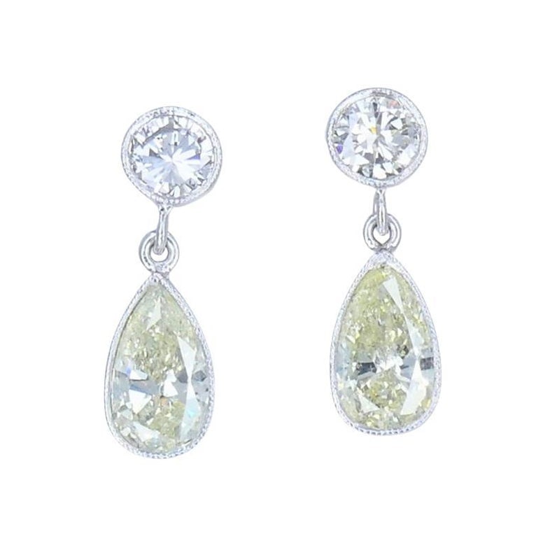 Art Deco platinum diamond drop earrings pear and round brilliant cuts: Art Deco platinum diamond drop earrings pear and round brilliant cuts Refined platinum drop earrings featuring diamonds in a classic Art Deco style. Each earring suspends an approximately 1.05-carat p