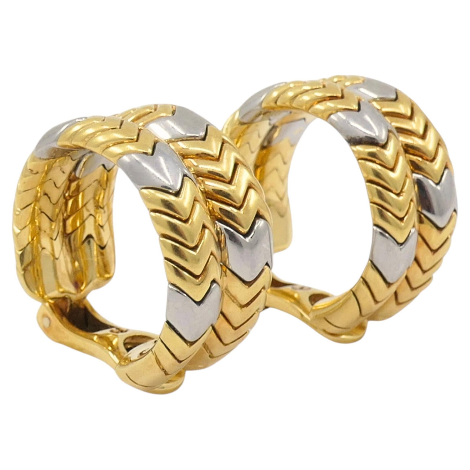 Bvlgari Spiga 18k Yellow and White Gold Hoop Earrings: Bvlgari Spiga 18k Yellow and White Gold Hoop Earrings Pair of Bulgari Spiga hoop earrings in 18k yellow and white gold, featuring the signature chevron pattern and two-tone finish. Compact in size, th