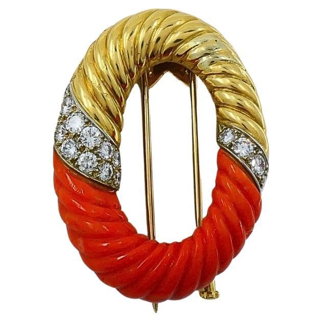 Bulgari Oval Brooch 18k Gold Coral and Diamond: Bulgari Oval Brooch 18k Gold Coral and Diamond An oval Bulgari brooch crafted in 18k yellow gold, featuring carved coral and a section of round brilliant-cut diamonds set in white gold. The piece is s