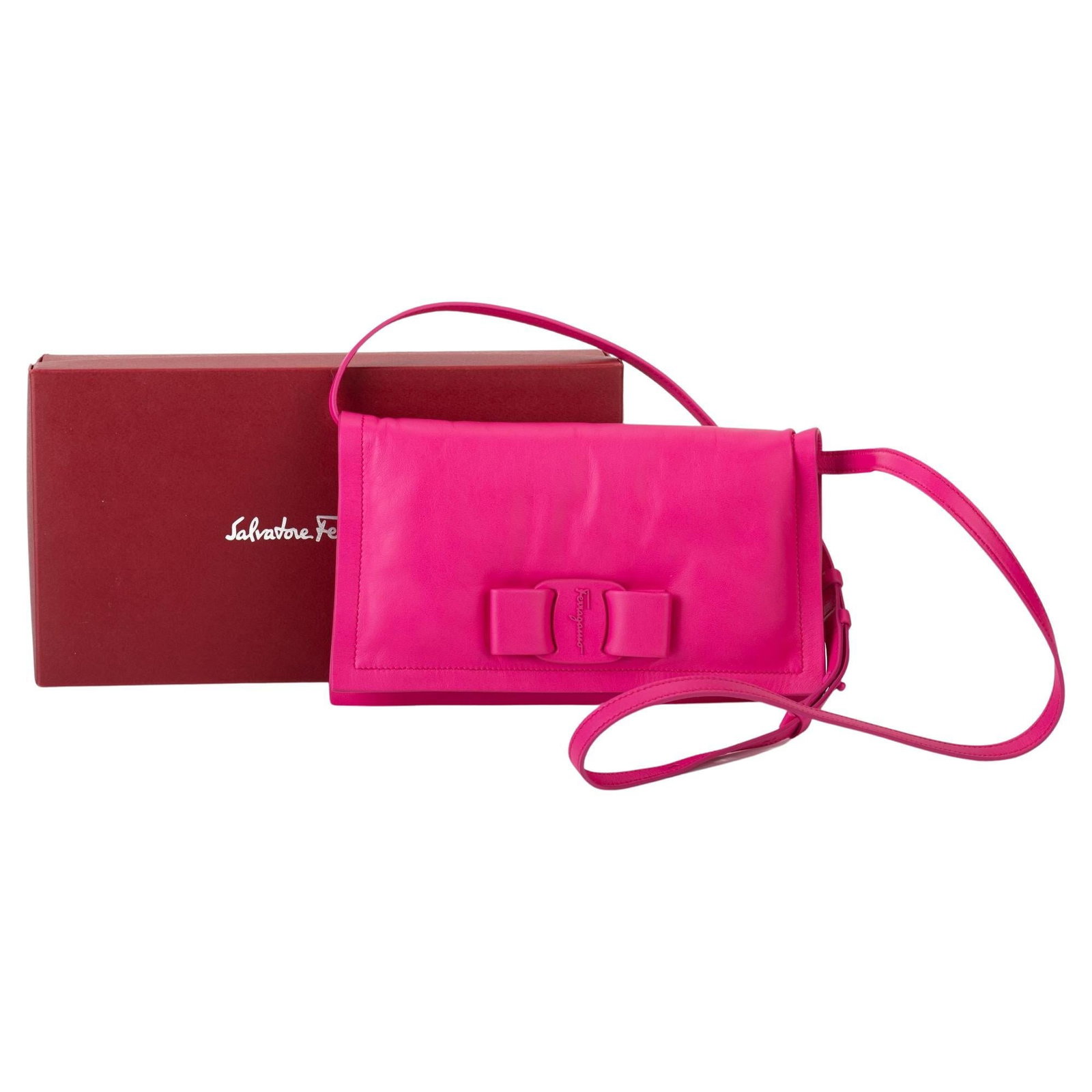 Ferragamo Fuchsia Leather Cross Body Mini Bow Bag Italy: Ferragamo Fuchsia Leather Cross Body Mini Bow Bag Italy Elevate your accessory collection with this Ferragamo fuchsia leather cross body mini bow bag. Crafted in Italy, this stylish bag boasts a sleek