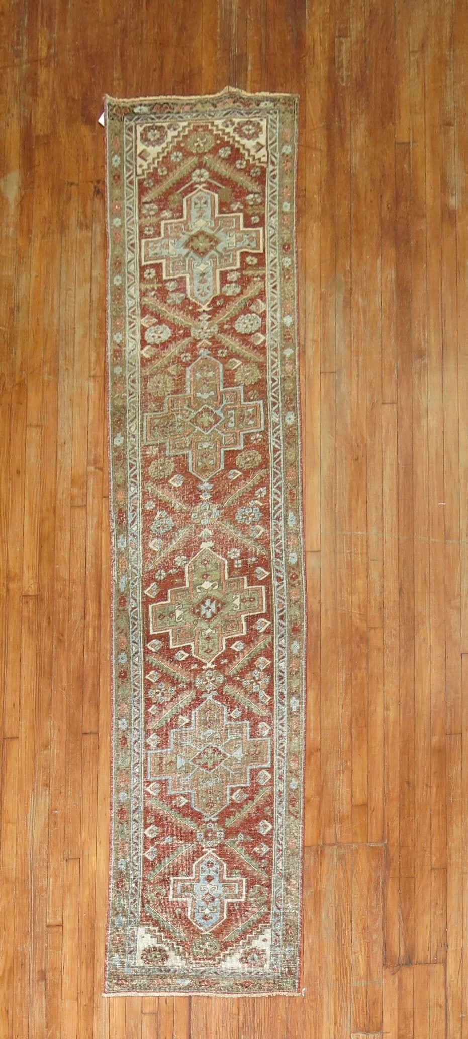 2' 4" x 10' 8" Persian Heriz Runner Reddish Brown Early 20th Century: 2' 4" x 10' 8" Persian Heriz Runner Reddish Brown Early 20th Century Antique Persian Heriz runner in a reddish brown palette, dating to the early 20th century. This pre-owned runner features the disti