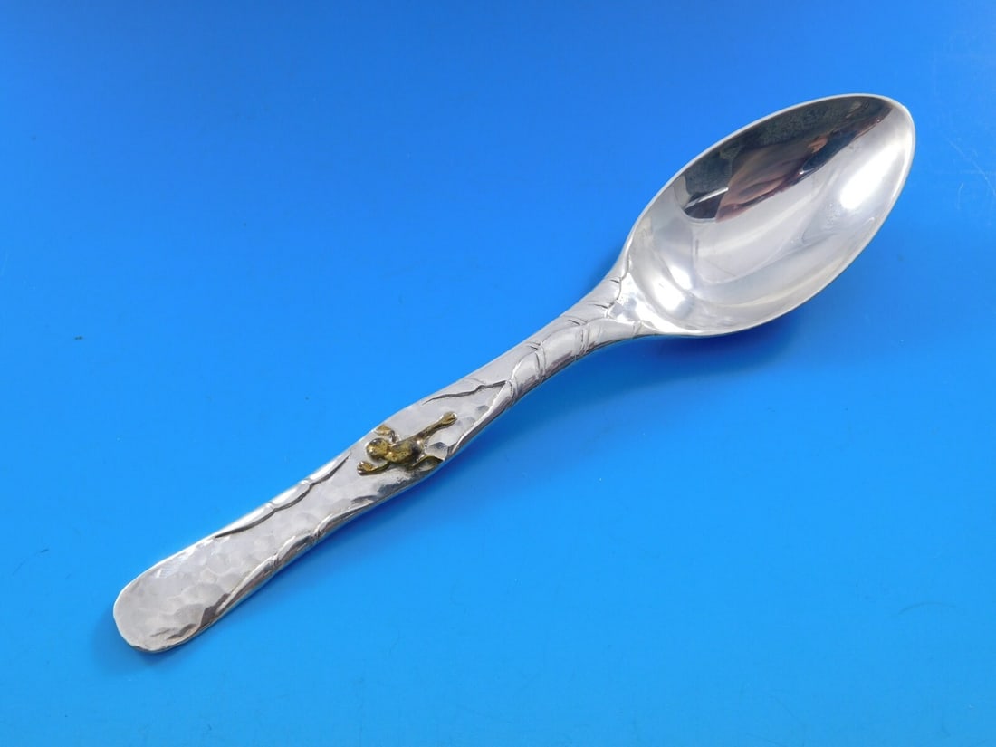 Tiffany & Co Lap Over Edge Teaspoon with Copper Frog 6 1/4: Tiffany & Co Lap Over Edge Teaspoon with Copper Frog 6 1/4 This exquisite Lap Over Edge Mixed Metals teaspoon from Tiffany & Co. showcases a beautiful blend of sterling silver and an applied copper fr
