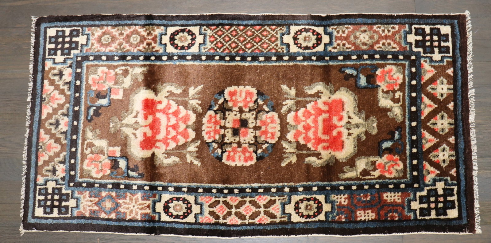 1' 10" x 3' 8" Chinese Yastik Rug Brown Floral: 1' 10" x 3' 8" Chinese Yastik Rug Brown Floral Small pre-owned Chinese floral Peking rug from the 1930s in a brown colorway. Classified as a yastik, this piece reflects Chinese and Tibetan type influe