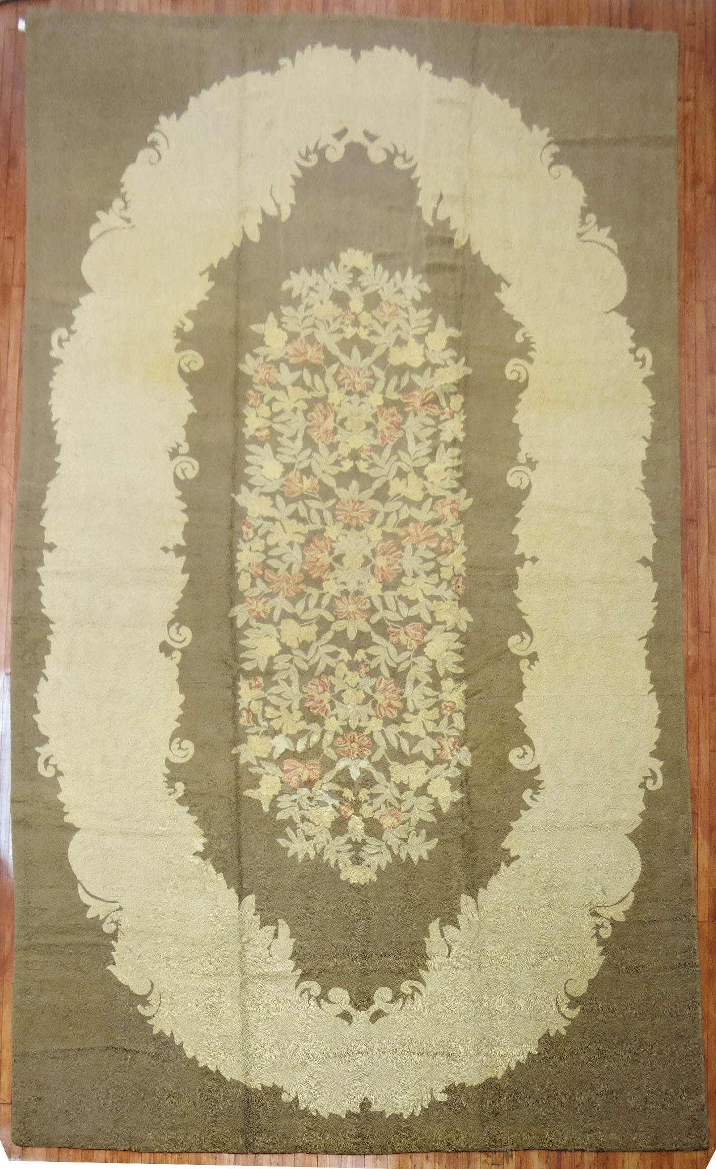 11' 3" x 21' 7" Oversize American hooked rug floral oval design: 11' 3" x 21' 7" Oversize American hooked rug floral oval design Large mid-20th century American handwoven hooked rug with an oval floral design in predominant soft brown, accented by earthy tones, sof