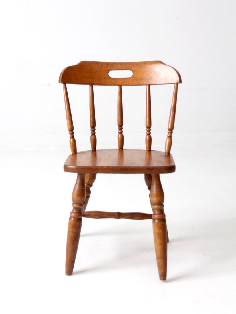 Early American Style Childs Wood Chair Mid Century: Early American Style Childs Wood Chair Mid Century Mid-century children's chair in Early American style with turned spindle supports, turned legs, and a shaped crest rail with a handhold cutout. The w