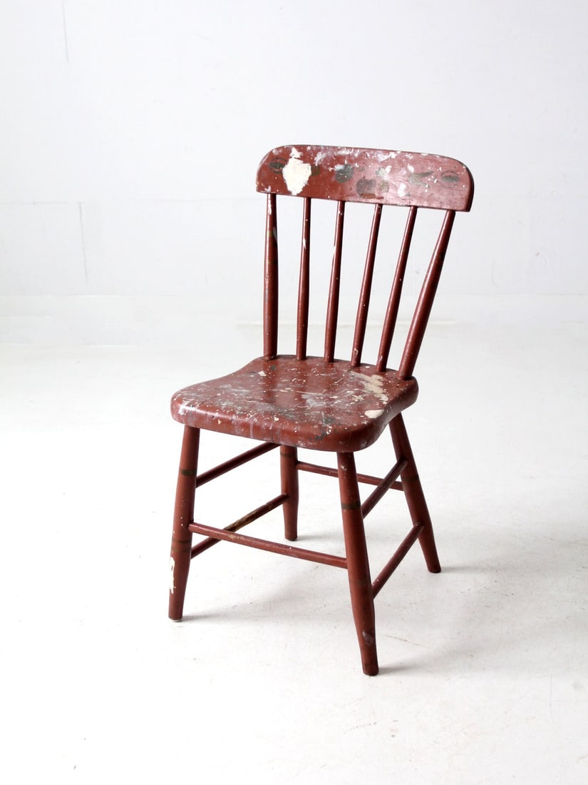 Rustic Antique Barn Red Spindle Back Chair Farmhouse Decor: Rustic Antique Barn Red Spindle Back Chair Farmhouse Decor This rustic antique spindle back chair showcases a charming barn red finish adorned with white paint splatters and a stencil design across it