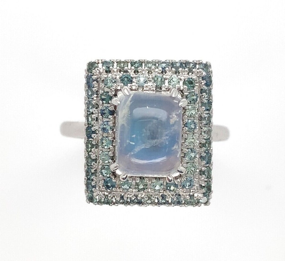 14k White Gold Moonstone Teal Sapphire Ring GIA Certified 3.21ct: 14k White Gold Moonstone Teal Sapphire Ring GIA Certified 3.21ct This exquisite 14k white gold ring showcases a captivating rainbow of colors with its genuine natural moonstone and teal sapphires. The