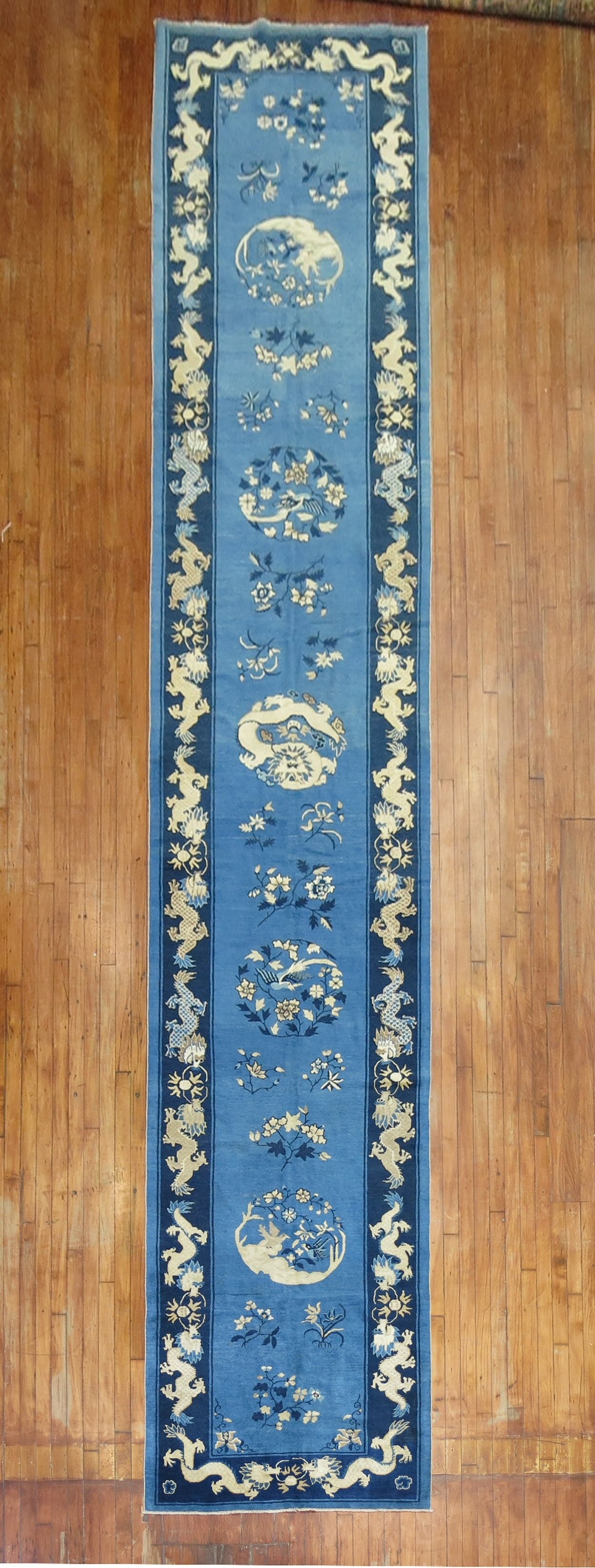 3' 6" x 20' 4" Chinese Peking pictorial dragon runner rug: 3' 6" x 20' 4" Chinese Peking pictorial dragon runner rug Early 20th century Chinese Peking pictorial runner featuring a dragon motif in various shades of blue and ivory. This pre-owned rug has a long