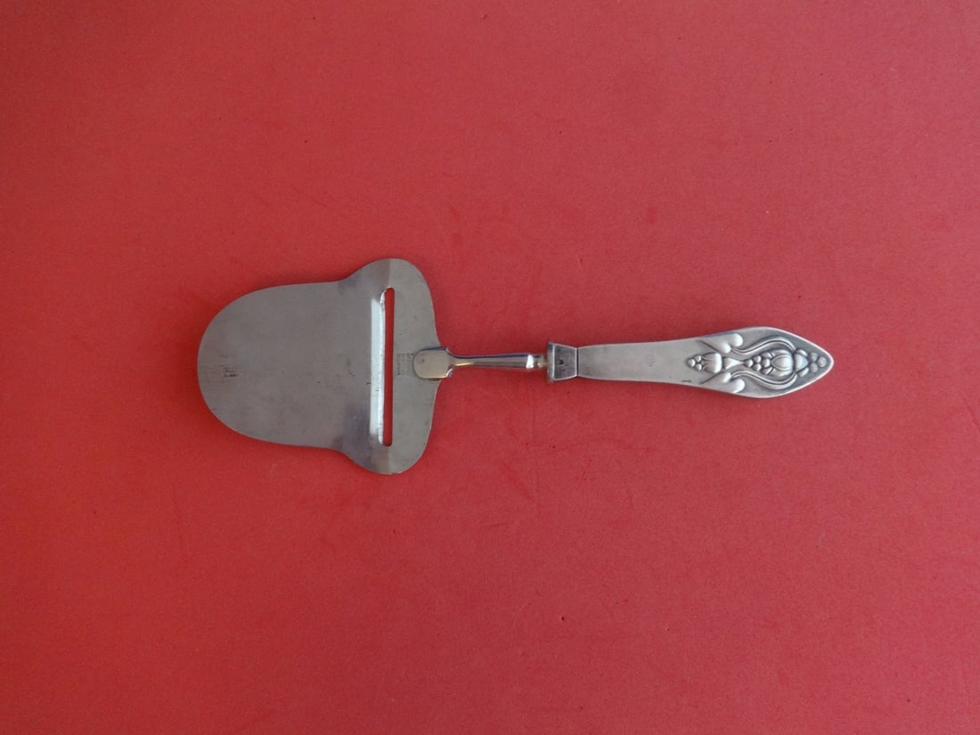 Georg Jensen Fuchsia Sterling Silver Cheese Plane Hollow Handle 8 1/4": Georg Jensen Fuchsia Sterling Silver Cheese Plane Hollow Handle 8 1/4" A Georg Jensen Fuchsia cheese plane in sterling silver with a stainless steel implement and hollow handle. This serving piece mea