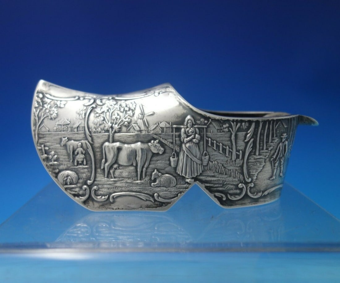 Dutch .830 Silver Ashtray Wooden Shoe Pastoral Scenes Cows Sheep: Dutch .830 Silver Ashtray Wooden Shoe Pastoral Scenes Cows Sheep This exquisite Dutch .830 silver ashtray is elegantly crafted in the unique form of a wooden shoe, showcasing charming pastoral scenes 