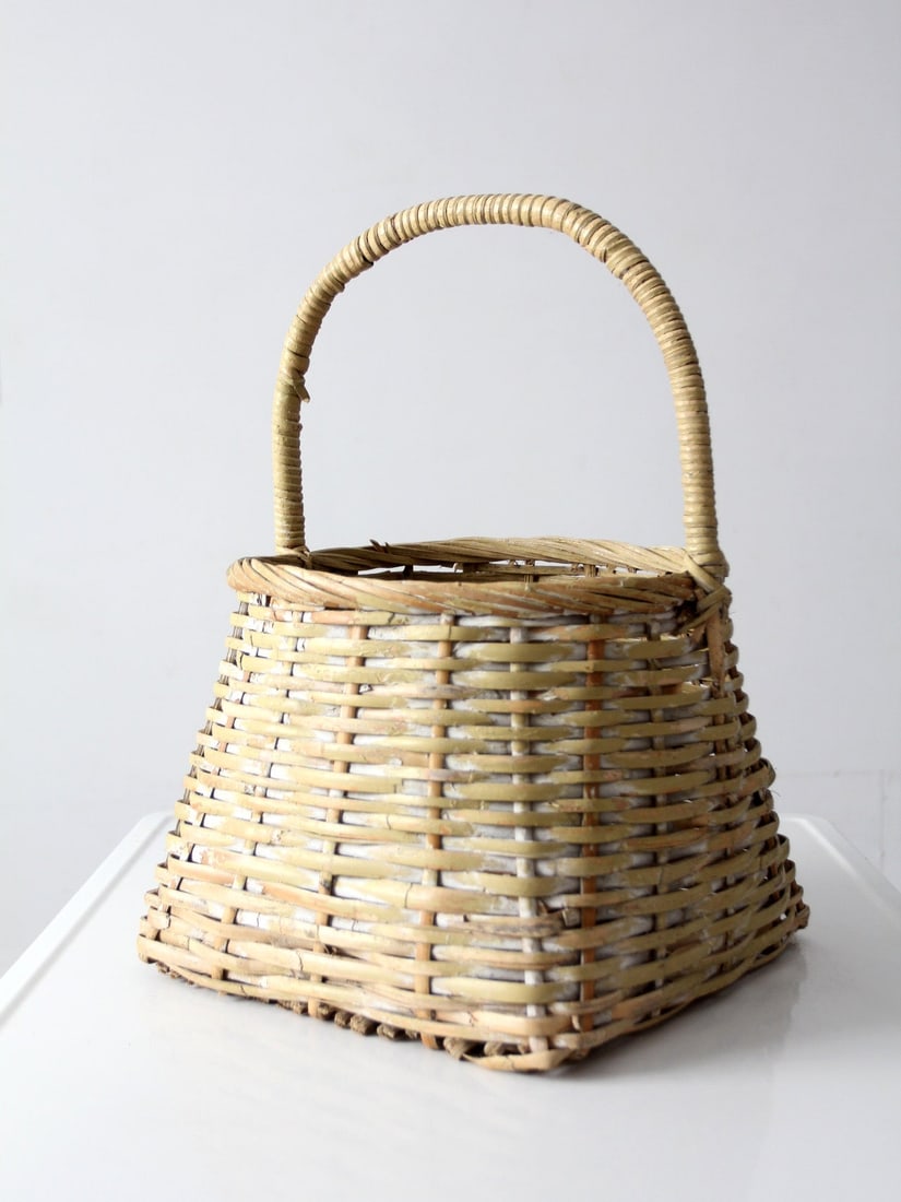 Antique Handmade Reed Basket With Arched Handle And Tapered Form: Antique Handmade Reed Basket With Arched Handle And Tapered Form This antique handmade gathering basket features a gently tapered silhouette and a wrapped arched handle. Its horizontal weave showcases