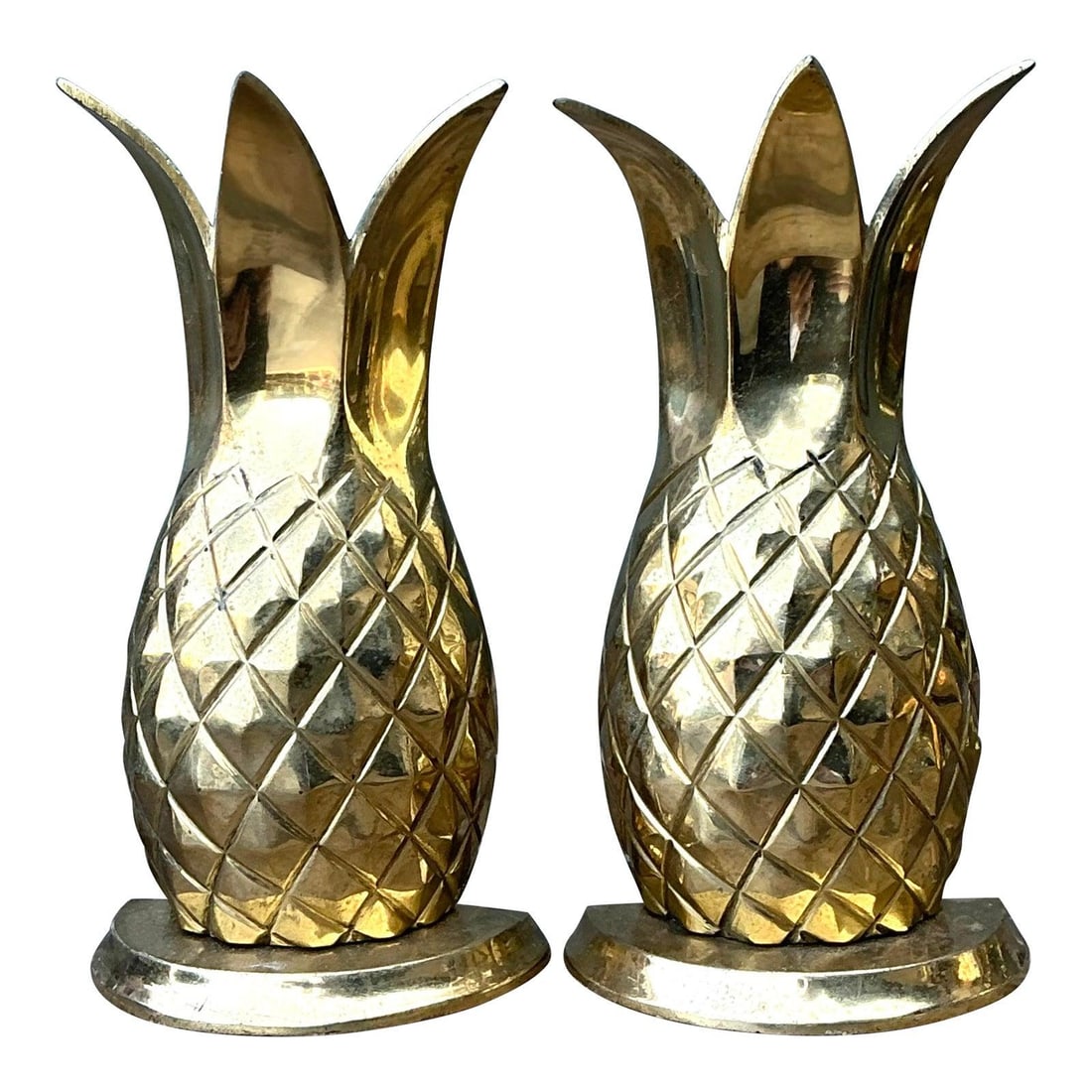 Pair of Brass Pineapple Bookends Set of 2: Pair of Brass Pineapple Bookends Set of 2 This set of vintage polished brass pineapple bookends brings a touch of warm hospitality and Hollywood Regency glamour to any space. Crafted from heavy, solid
