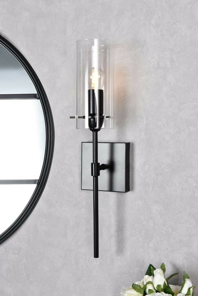 Elsreth Black Metal Wall Sconce with Clear Glass Shade 1 Light: Elsreth Black Metal Wall Sconce with Clear Glass Shade 1 Light This modern wall sconce features a sleek black metal frame paired with a clear glass shade, offering a stylish lighting solution for indo