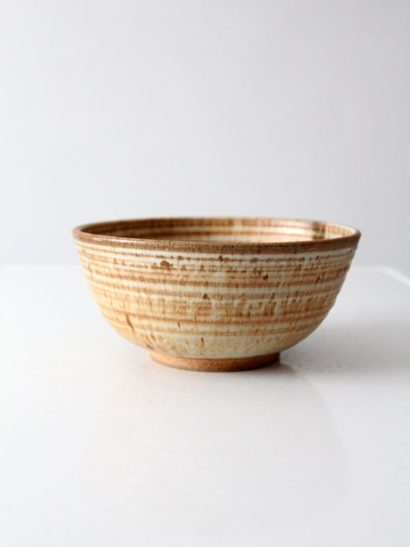 Wheel Thrown Studio Pottery Serving Bowl with Layered Glaze: Wheel Thrown Studio Pottery Serving Bowl with Layered Glaze Vintage handmade studio pottery serving bowl with a wheel-thrown form and layered cream, honey, olive, and deep brown glazes. The softly rib